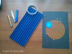 a table with pens, pencils and an object on it that looks like a solar system