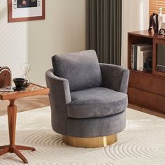 a grey chair sitting on top of a white rug next to a wooden coffee table