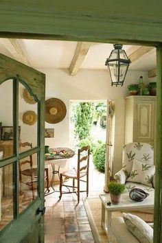 an open door leading into a living room with chairs and tables in the center area