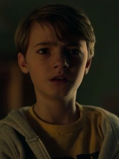 a young boy is staring at the camera with an intense look on his face and chest