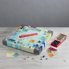 a monopoly board game on a wooden table with pieces of paper and dice scattered around it