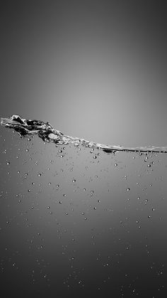 black and white photograph of water with bubbles on the surface, taken from below it