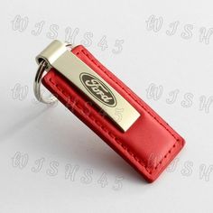 a red leather keychain with a metal name tag