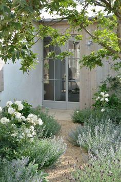 the house is surrounded by flowers and trees