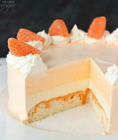 a white cake with orange and white frosting on it's top is sitting on a plate