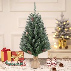 a small christmas tree sitting on top of a table next to presents and other decorations