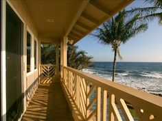 a balcony overlooking the ocean with palm trees