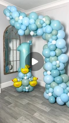 a balloon arch with rubber ducks and blue balloons in the shape of an o - letter