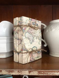 a wooden box sitting on top of a shelf next to white vases and cups