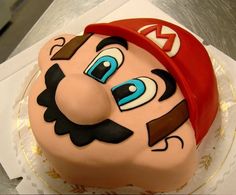 there is a cake that looks like a mario bros character on it's face