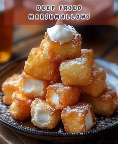 a pile of deep fried marshmallows sitting on top of a black plate