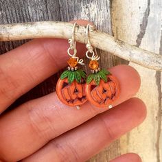 "These adorable little jack o lantern pumpkins will definitely bring you some Halloween cheer. These tangerine orange carved howlite stones are accented with genuine copper hand patinaed green bead caps on top that resemble the stem of the pumpkin. Atop the green leaves sits a sparkly orange Swarovski crystal. They measure 1 1/2\" in length from the top of the sterling silver earwires and 5/8\" in width. **Ready to ship in 3-5 days** See more Halloween and Autumn Earrings here: See more of my je Halloween Earrings Diy, Handmade Holiday Jewelry, Halloween Jewelry Diy, Mary Jewelry, Halloween Beaded Jewelry, Lantern Pumpkins, Lantern Earrings, Thanksgiving Jewelry, Autumn Earrings