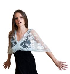 Step into the realm of timeless elegance with our Silver Lace Loop Shawl - a captivating and lightweight accessory that elevates your look in four different ways: as a shrug, shawl, crisscrossed shawl, or scarf. The exquisite silver hue exudes sophistication and glamour, making it a perfect choice for special occasions and refined events. Available in three sizes for a flawless fit: Petite (US 0-6) One size (US 8-14) Plus size (US 14-22) This exquisite shawl comes with wearing instructions, beautifully presented in a printed gift bag, making it a thoughtful and charming gift option for your loved ones. Additionally, we've thoughtfully included a QR code linked to the movie clip, granting you easy access to styling ideas. Experience the elegance in our YouTube clip: http://www.youtube.com/w Balochi Dress, Lace Bolero, Bridal Shawl, Gala Events, Lace Wrap, Lace Shawl, Wrap Shawl, Movie Clip, Shawls And Wraps