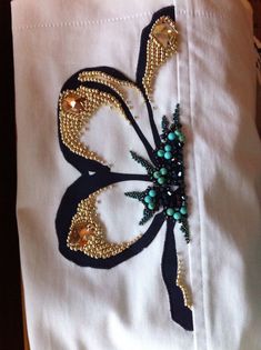 a close up of a piece of cloth with beading on it and a flower