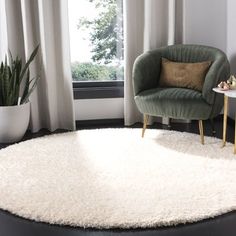 a living room with a chair and rug in front of a large window on the floor