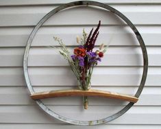 a bunch of flowers sitting on top of a wooden shelf