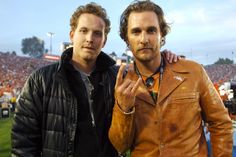 two men standing next to each other at a football game