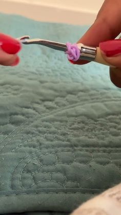 a woman is using a pair of scissors to cut the edge of her manicured nails