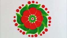 a red flower with green leaves and dots in the center on a white surface,