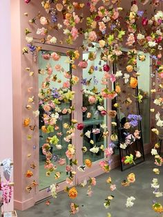 a room filled with lots of fake flowers hanging from the ceiling and on the walls