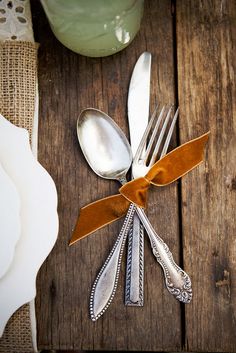 silverware with brown ribbon on wooden table