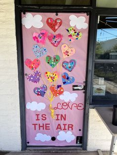 a door decorated with hearts and the words love is in the air