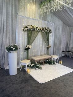 a wedding ceremony setup with white flowers and greenery