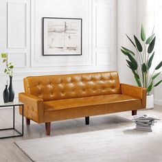 a brown leather couch sitting on top of a white rug in a living room next to a potted plant