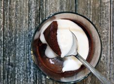 there is a spoon that is in the cup with ice cream and chocolate cake on it