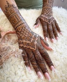 a woman's hands with hennap on top of white furnishing