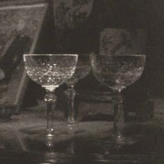 three wine glasses sitting on top of a table