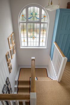 an aerial view of a staircase leading up to a stained glass window in a house