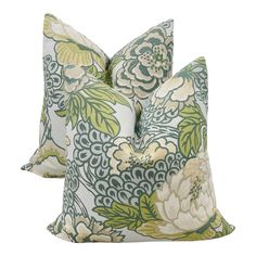 two green and white floral pillows on top of each other, one with a flower pattern