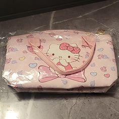 a pink hello kitty purse sitting on top of a table