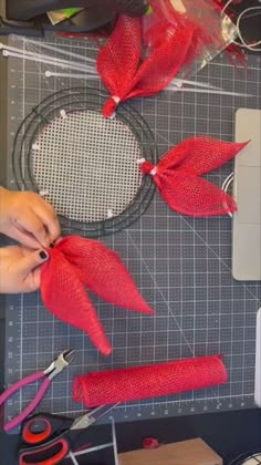 someone is working on some red bows with scissors