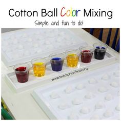 a table topped with cups filled with different colored dyes next to an ice tray