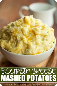 mashed potatoes in a white bowl on a wooden cutting board with the words bourbon cheese mashed potatoes