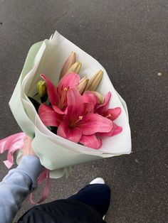 a person holding a bouquet of pink flowers