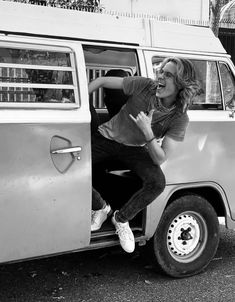 a woman sticking her head out the window of a van