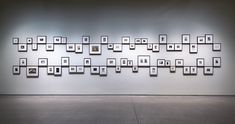 an art gallery with multiple frames on the wall and floor, all arranged in different sizes