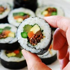 sushi is being held in the palm of someone's hand