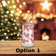 a glass jar with candy canes on it sitting on a table in front of a christmas tree