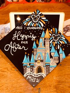 a graduation cap with the words and i graduated happily ever after on it sitting on top of a table