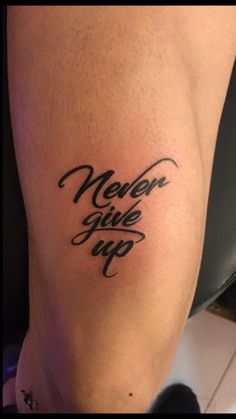 a woman's leg with the words never give up written on her left thigh