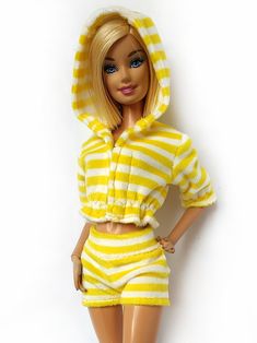 a barbie doll wearing a yellow and white striped outfit with her hands on her hips