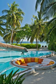 an outdoor swimming pool surrounded by palm trees