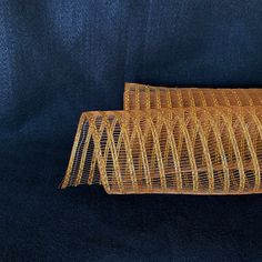 two pieces of yellow woven material sitting on top of a blue cloth covered tablecloth