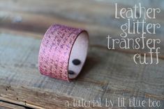 a close up of a wooden surface with a pink and black glitter tape on it