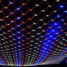 colorful lights are on the ceiling in front of a black background with white and blue dots