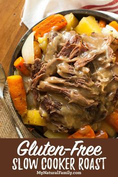 a pot roast with gravy and carrots in a skillet on a table